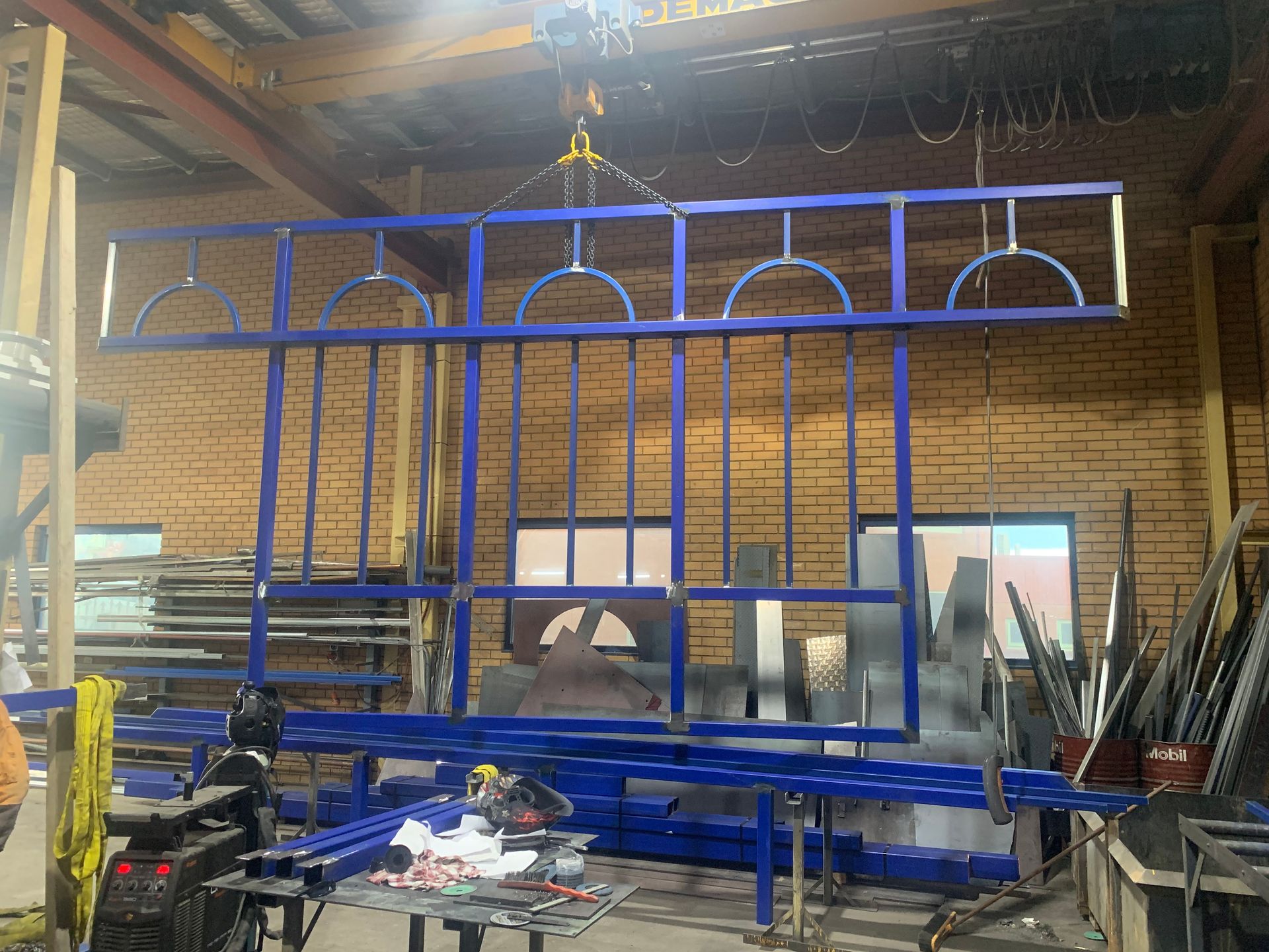 A large blue metal structure is being built in a factory — Magnum Steel In Crestwood, NSW