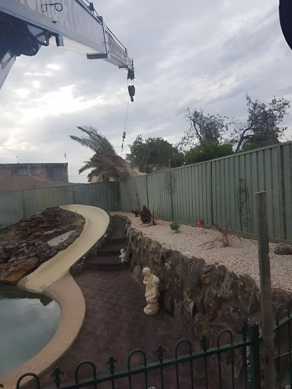 A Crane Is Lifting A Tree In A Backyard Next To A Pool — All Area Tree Service Pty Ltd In Fountaindale, NSW