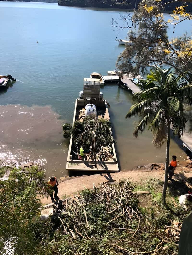 A Boat Is Docked In The Water Next To A Dock — All Area Tree Service Pty Ltd In Fountaindale, NSW
