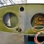 Close-up of a wing interior showing circular openings, metal components, and wiring.