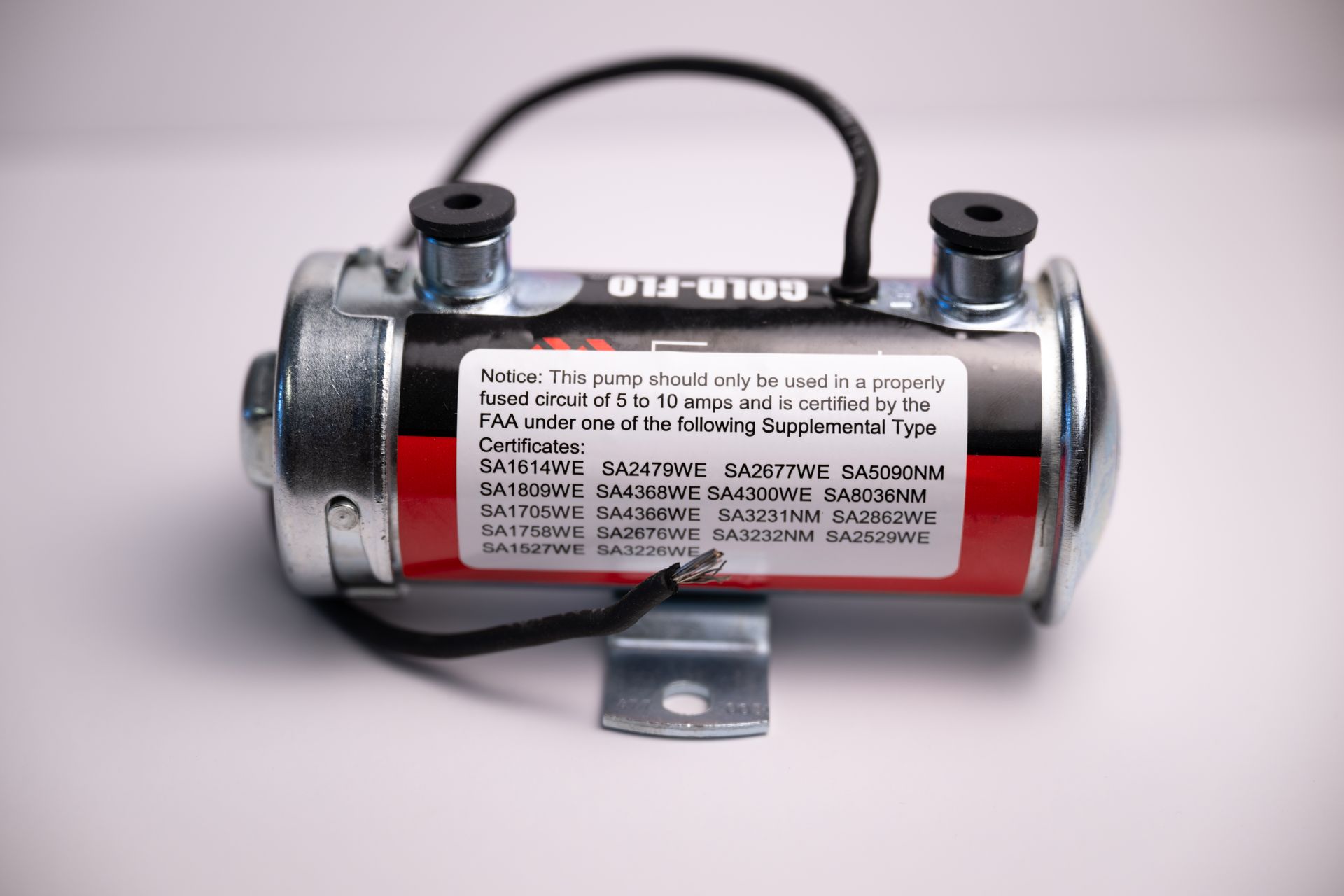 Fuel pump, cylinder-shaped with red and silver casing, black tubing, and mounting bracket.