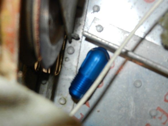Blue bolt in a metal frame, near a metallic object with rivets and a wire.