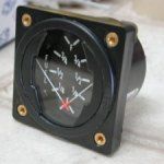 Black fuel gauge shows the needle indicating nearly empty. Four gold screws secure the black housing.
