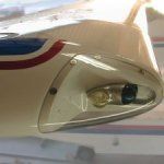 Wing tip with navigation light, white with red and blue stripes.