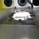 Metal aircraft interior with a central opening and black hardware.