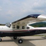Black and white airplane with red stripe on a runway.