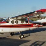 Red and white Cessna airplane parked on a tarmac, with the tail number N4576K visible.