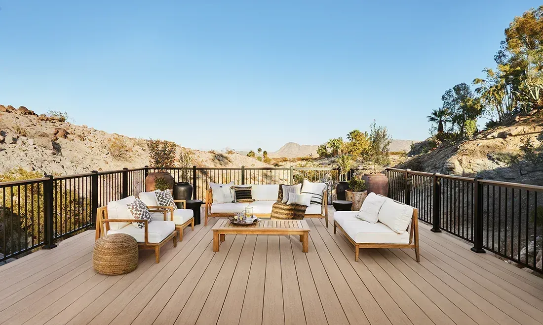 Yellow patio furniture, including a love seat, two rocking chairs, and a coffee table, on a paved outdoor patio.