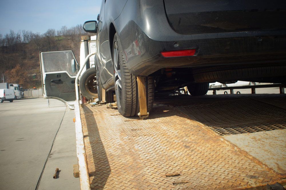 A Car Is Sitting On Top Of A Tow Truck — Gympie/Childers Towing Pty Ltd in Childers, QLD