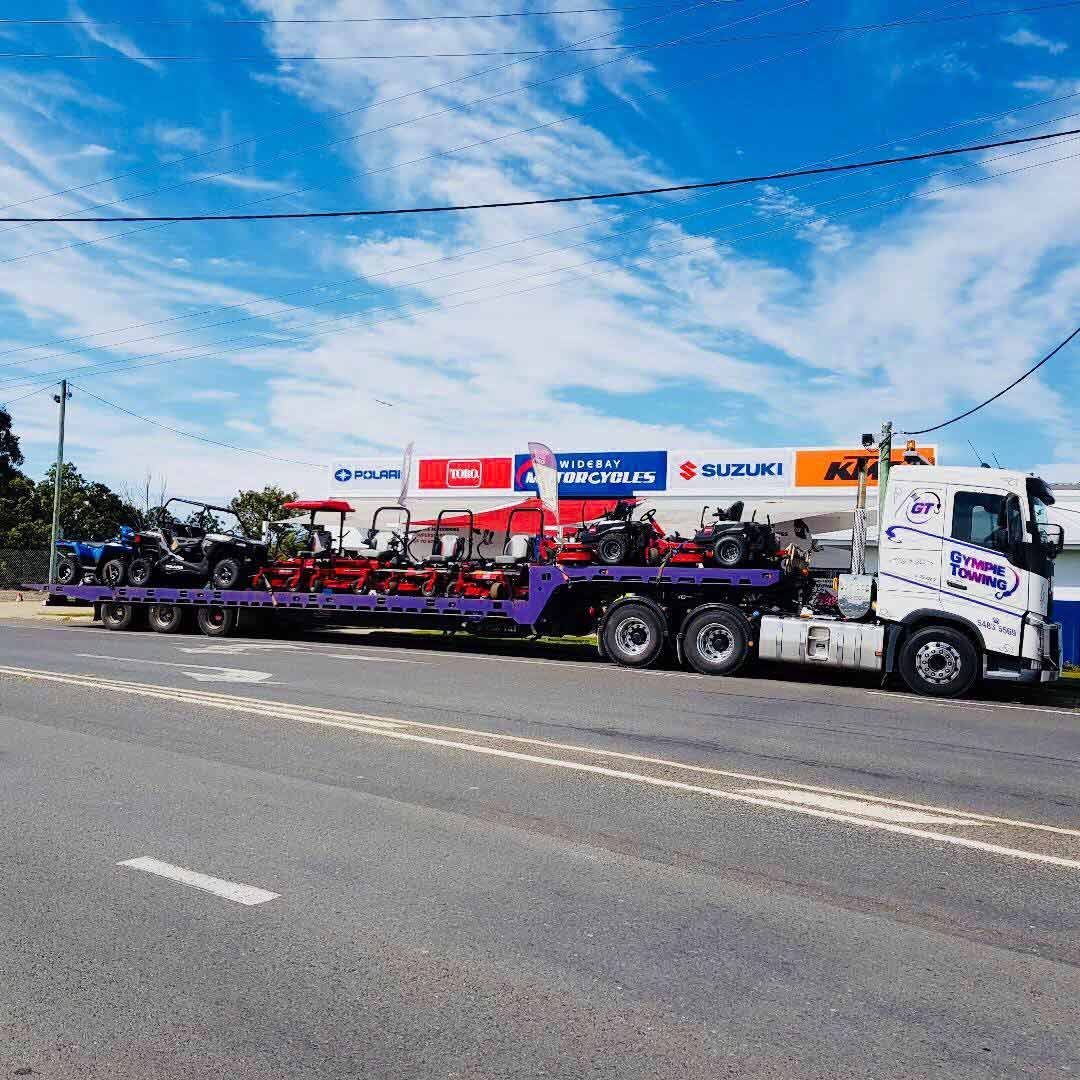 A Truck With A Trailer Full Of Motorcycles Is Parked On The Side Of The Road — Gympie/Childers Towing Pty Ltd in Kybong, QLD
