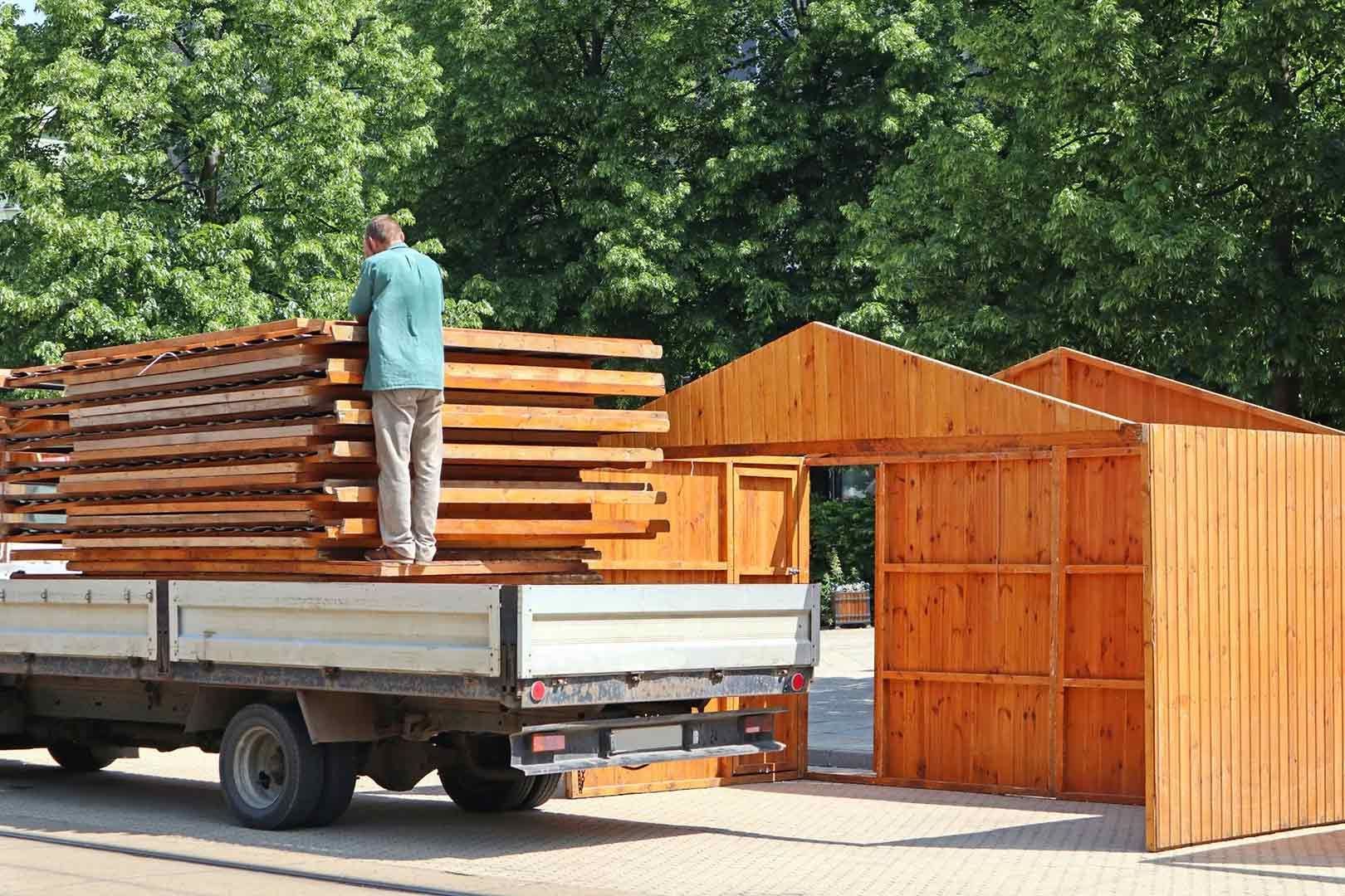 A Man Is Loading Wood Into The Back Of A Truck — Gympie/Childers Towing Pty Ltd in Kybong, QLD