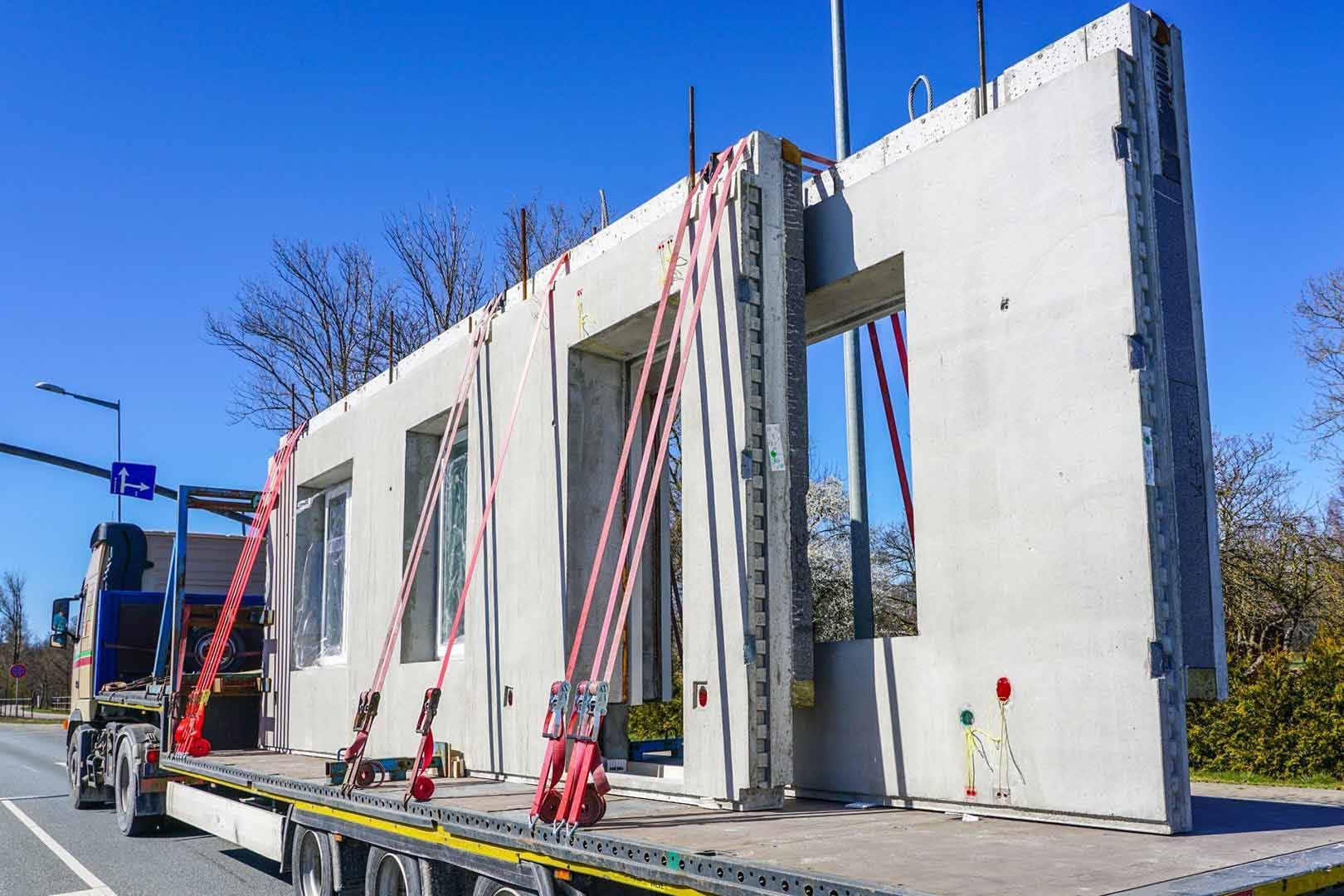 A Truck Is Carrying A Concrete Wall On The Back Of It — Gympie/Childers Towing Pty Ltd in Kybong, QLD