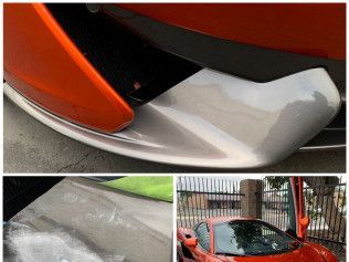 Damaged orange sports car bumper and shattered clear plastic panel close-up