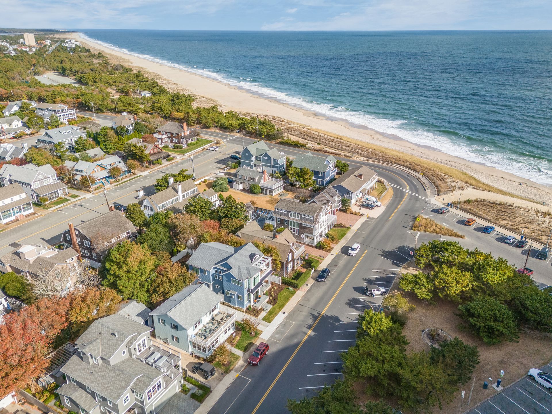 Aerial view of a coastal neighborhood beside a sandy beach and blue ocean