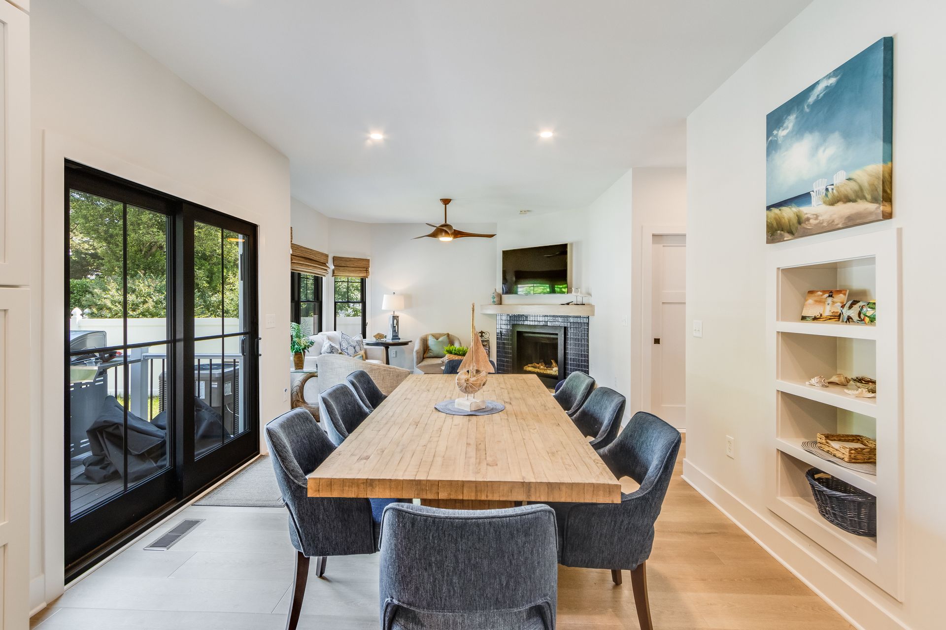 Dining room with a long wooden table, blue chairs, and a fireplace.