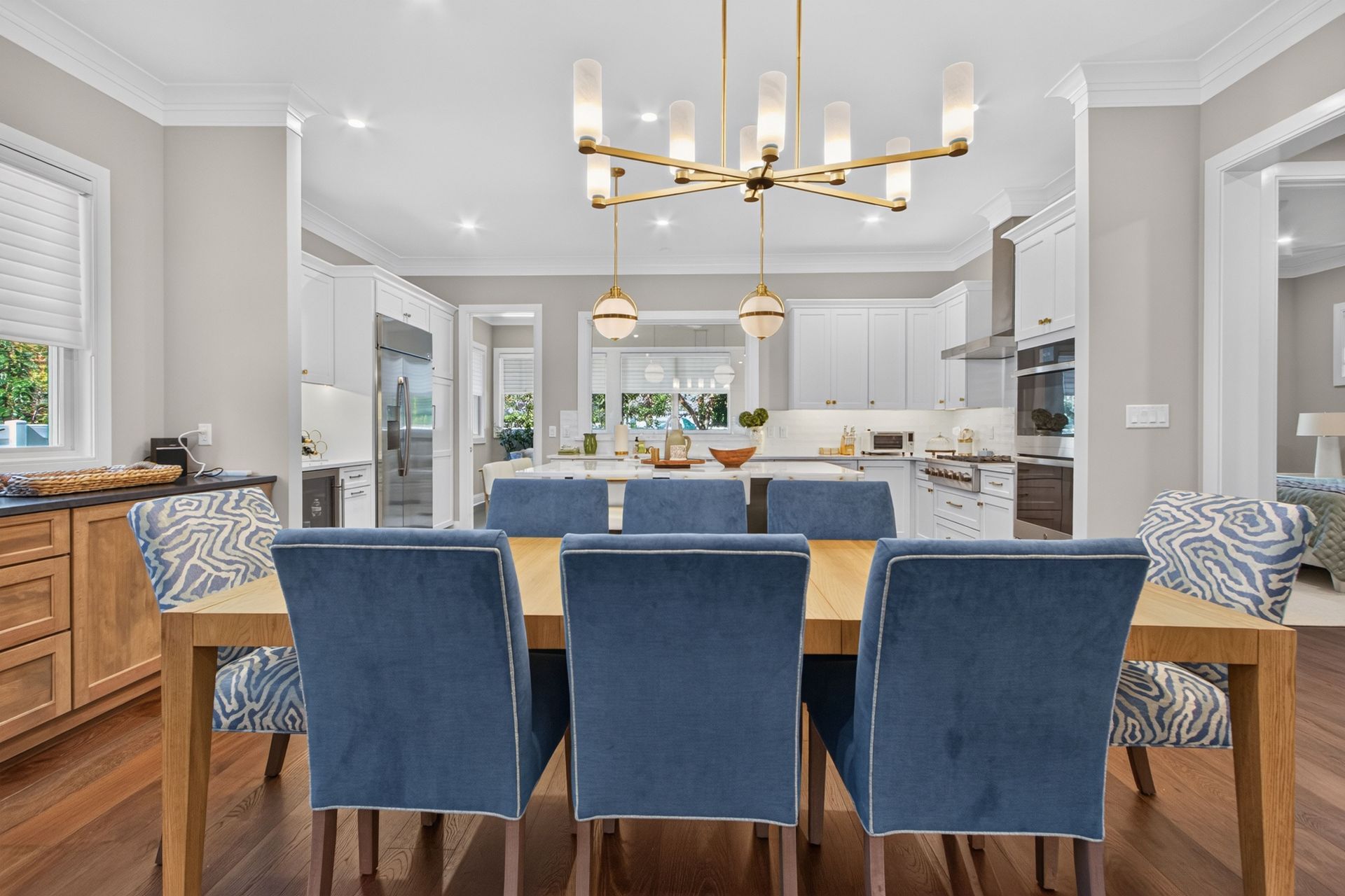Bright kitchen with blue bar stools, white cabinets, and gold pendant lights￼