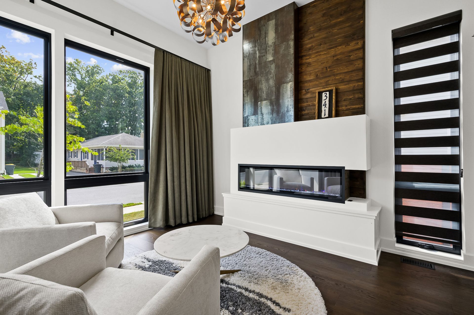 Living room with modern fireplace, large windows, and contemporary furniture.