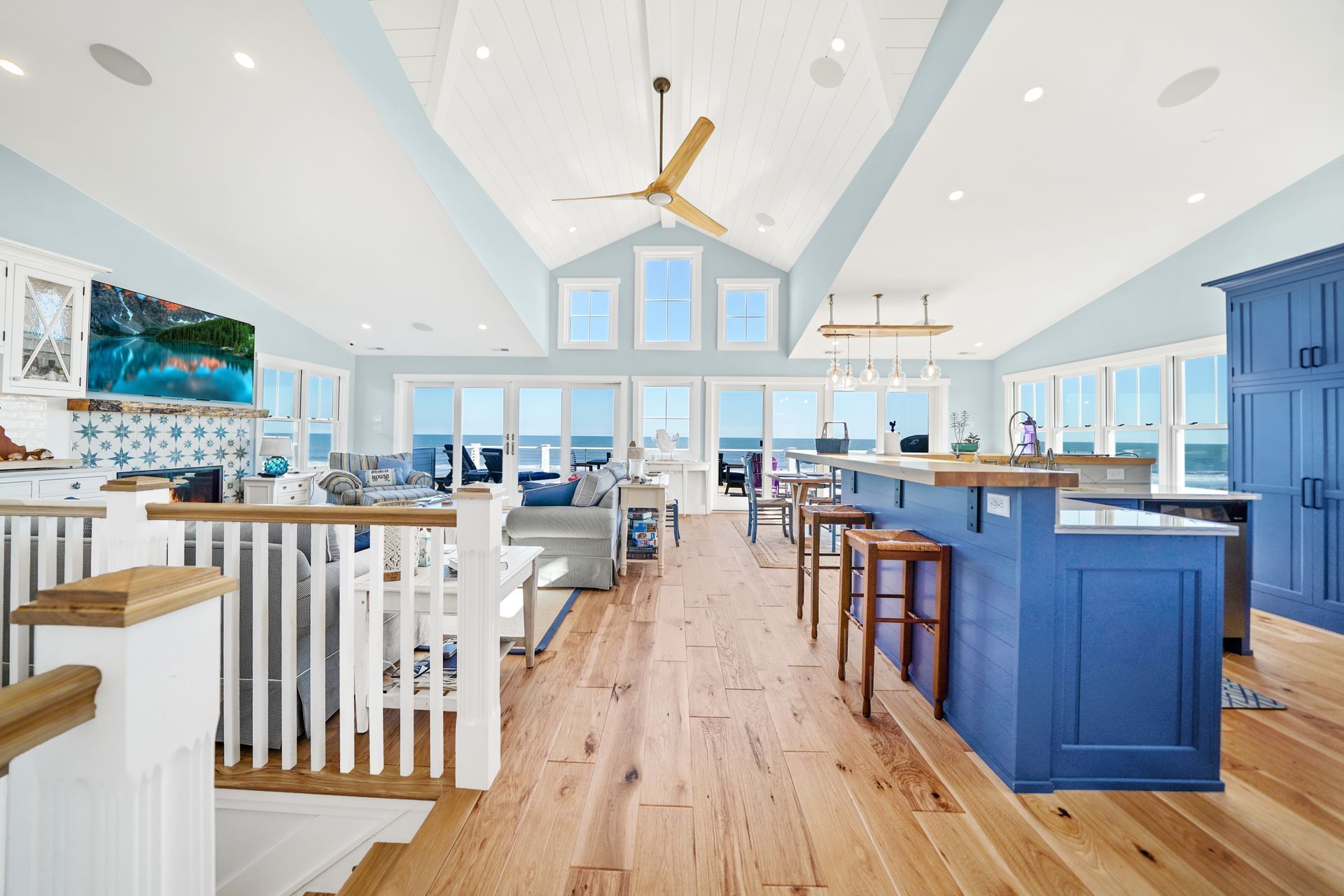 Spacious coastal home interior with blue accents, high ceilings, and ocean views.