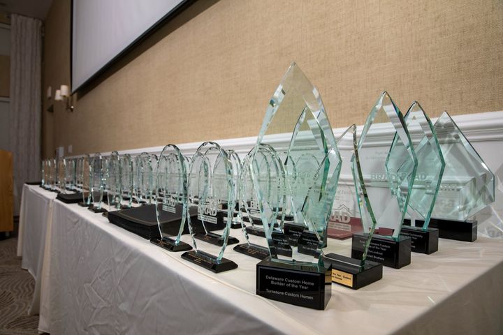 Awards on a white tablecloth, glass trophies in a row at an event.