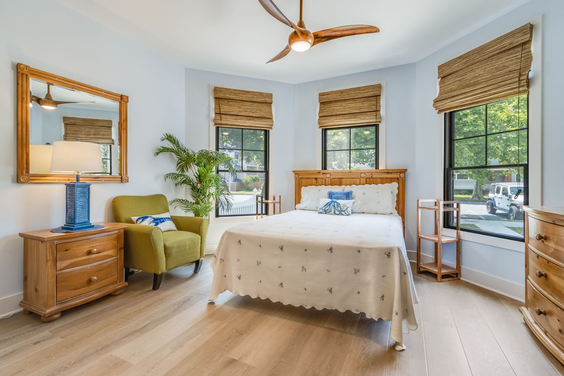 Bedroom with bed, chair, and dresser. Neutral tones with natural wood and blue accents.