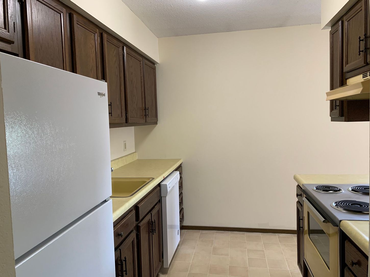 a kitchen with brown cabinets and a white refrigerator