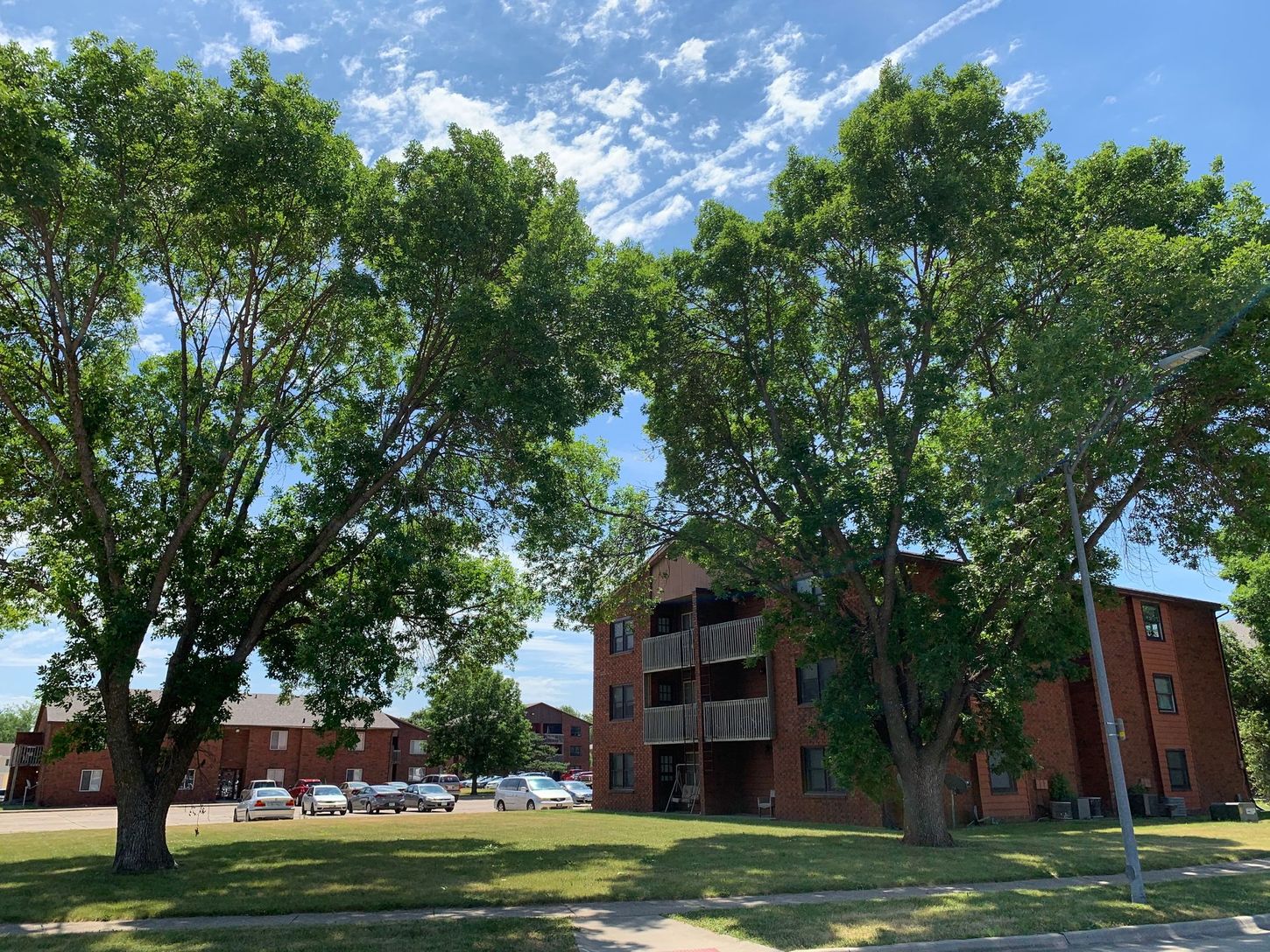 a large apartment building with a lot of trees in front of it .