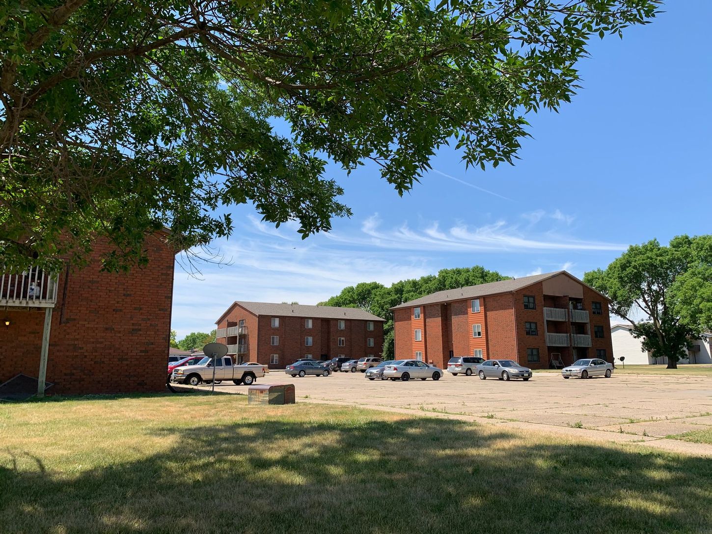 a large brick apartment building with a lot of cars parked in front of it .
