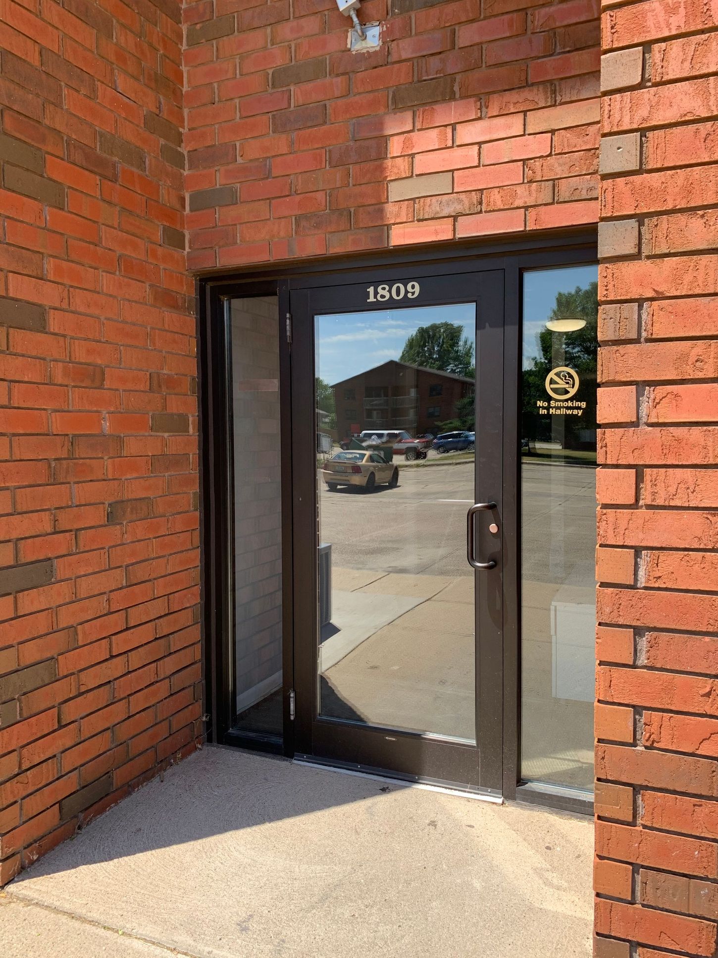 a brick building with a glass door and a car parked in front of it .