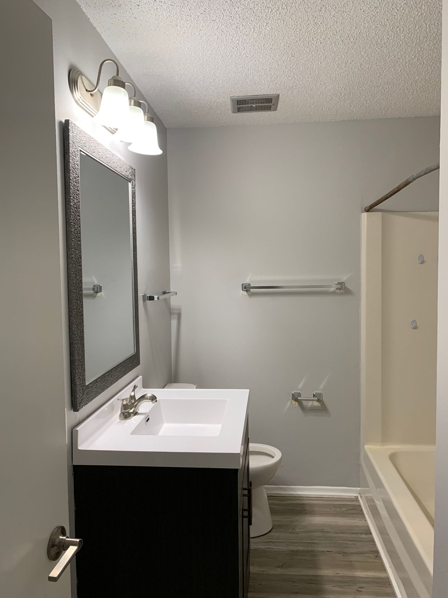 a bathroom with a toilet , sink and mirror