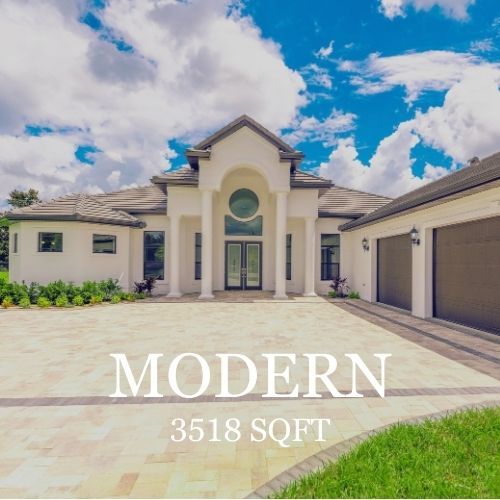White modern house with a paved driveway and blue sky.