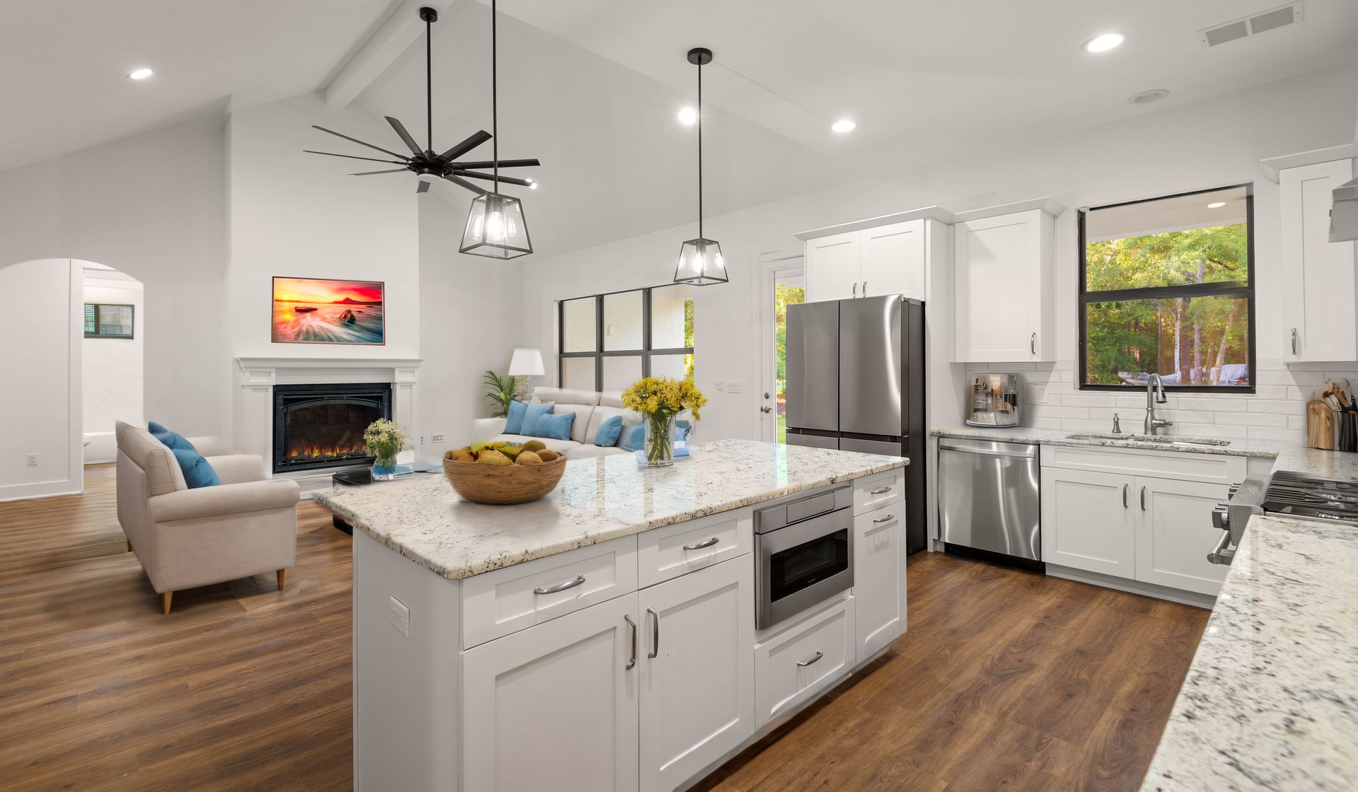 Spacious kitchen with a large island, wooden cabinets, and a range hood; neutral color palette.