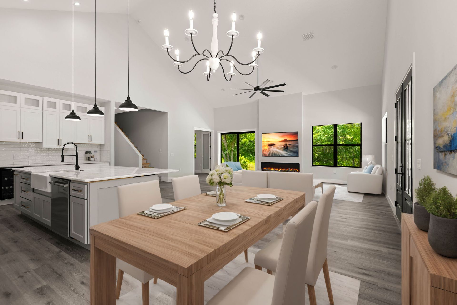 Open-concept living space with kitchen, dining area, and living room. White walls, wood floor, modern furniture, chandelier.