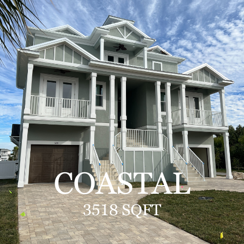 Coastal home with grey siding, white trim, and a brick driveway.