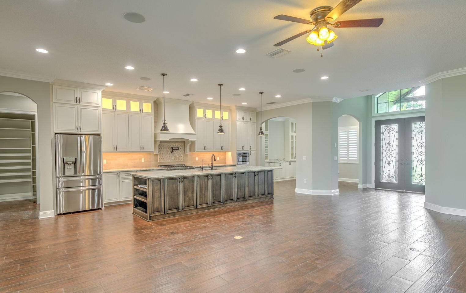 Spacious kitchen with a large island, stainless steel appliances, and wood flooring.