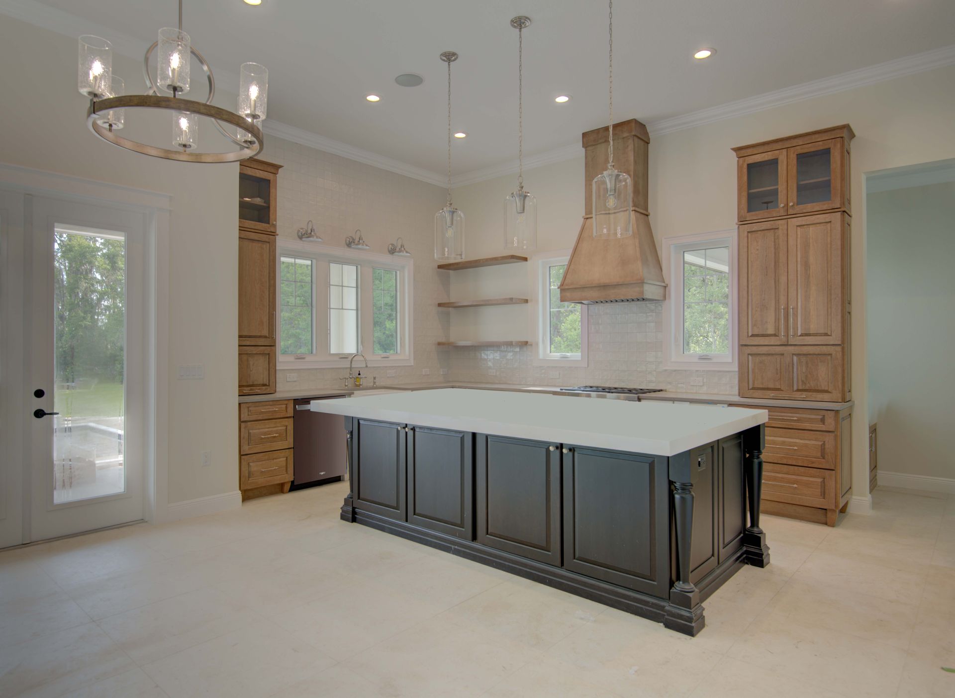 Empty kitchen with island, wooden cabinets, and a range hood; neutral color palette.