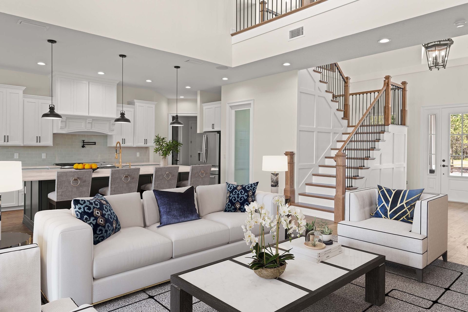 Living room with white sofa, kitchen, and staircase. Bright interior, modern design.