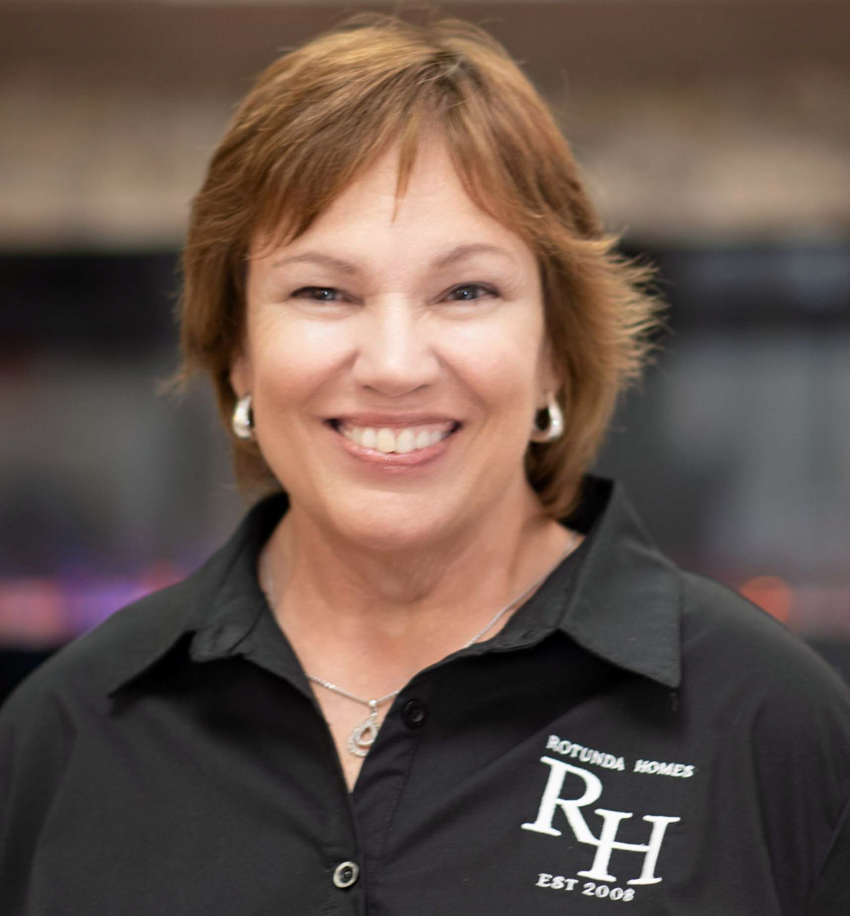 Woman smiling, wearing a black shirt with