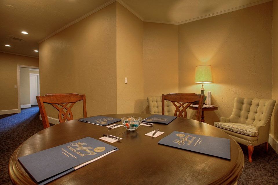 A conference room with a round table and chairs and a lamp.
