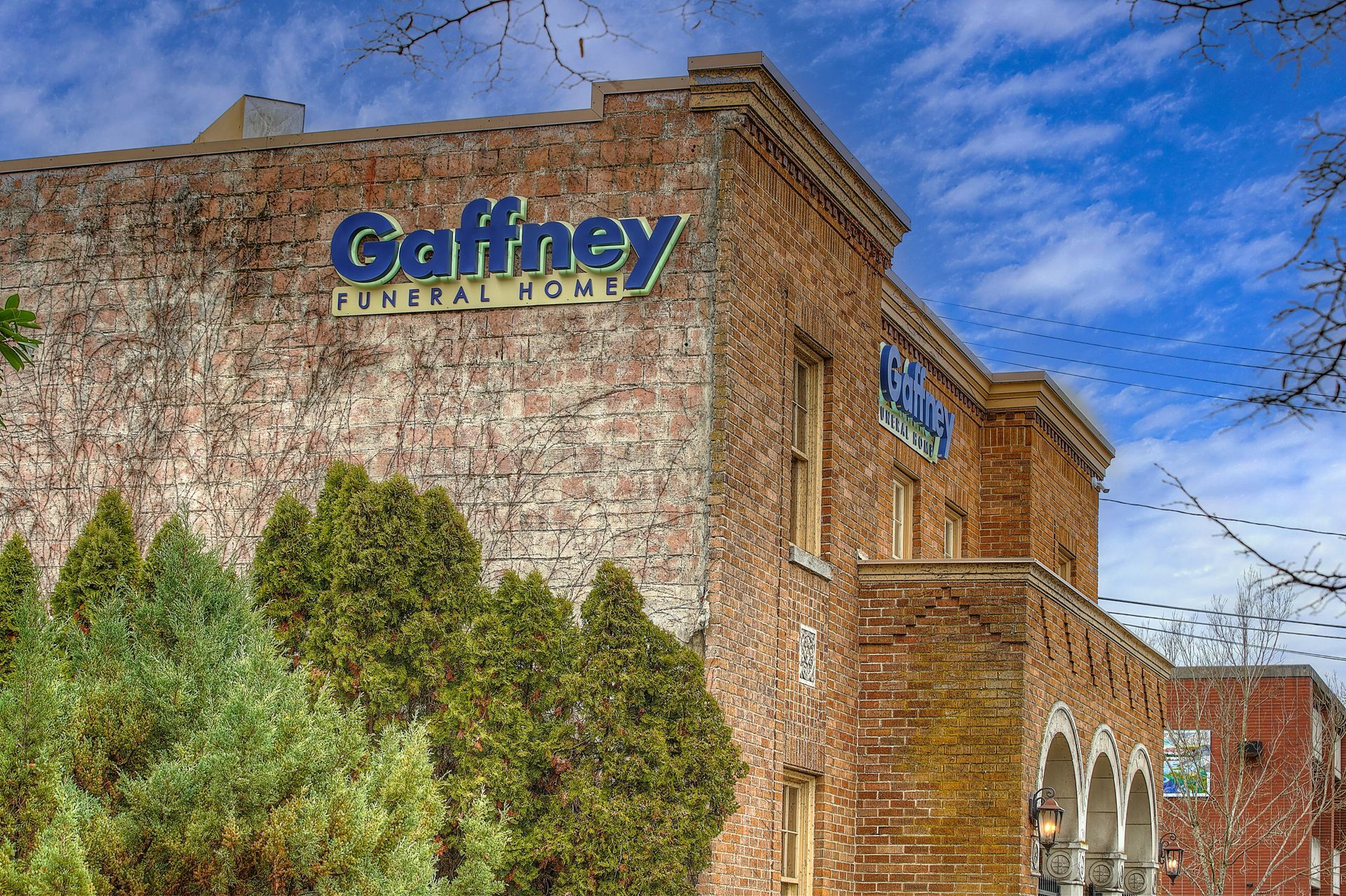 A brick building with a blue and yellow logo on the door