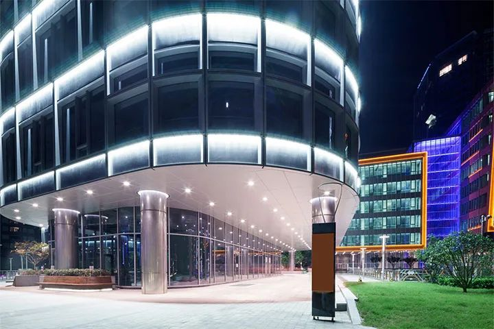 A large building with a lot of windows is lit up at night.