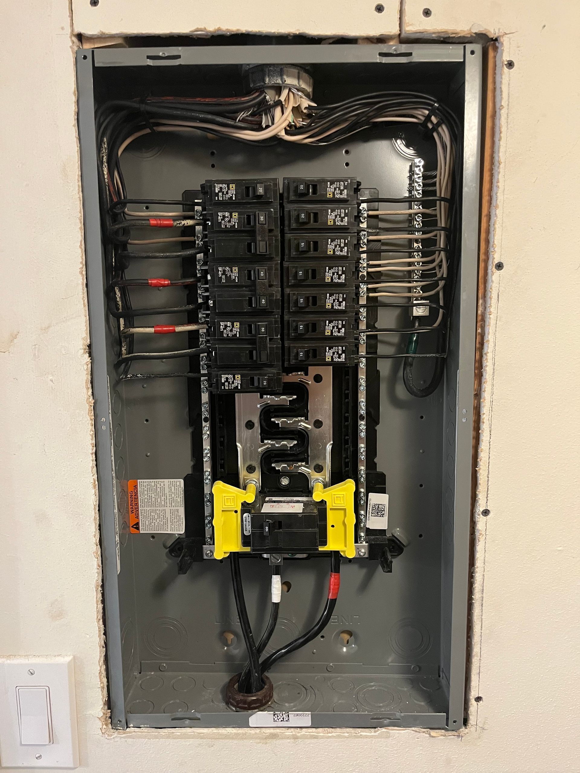 Two men are working on an electrical box.