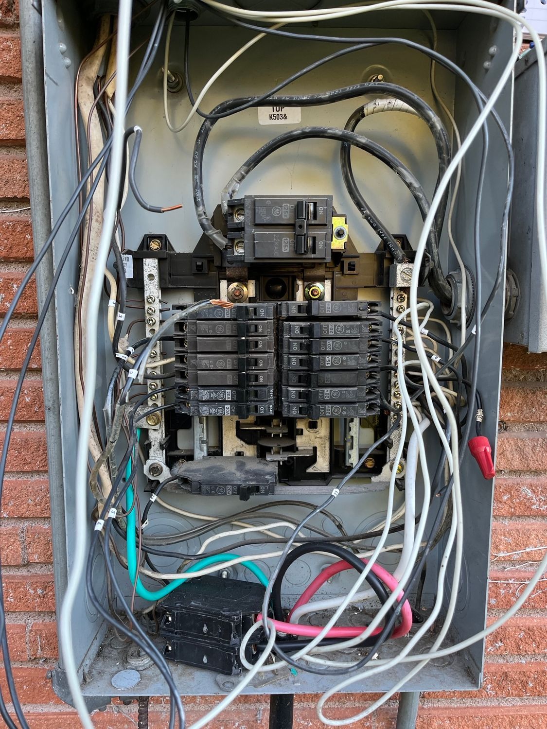 A person is pressing a button on an electrical box.