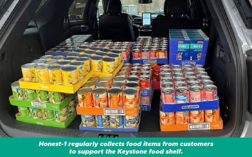 Car trunk filled with neatly stacked canned goods and boxes, with a banner about collecting food items for support homes.