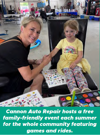Volunteer painting a young child’s hand at a community summer event with games and activities