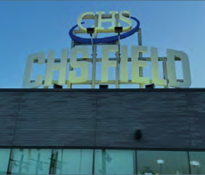 CHS Field sign on a building roof against a blue sky