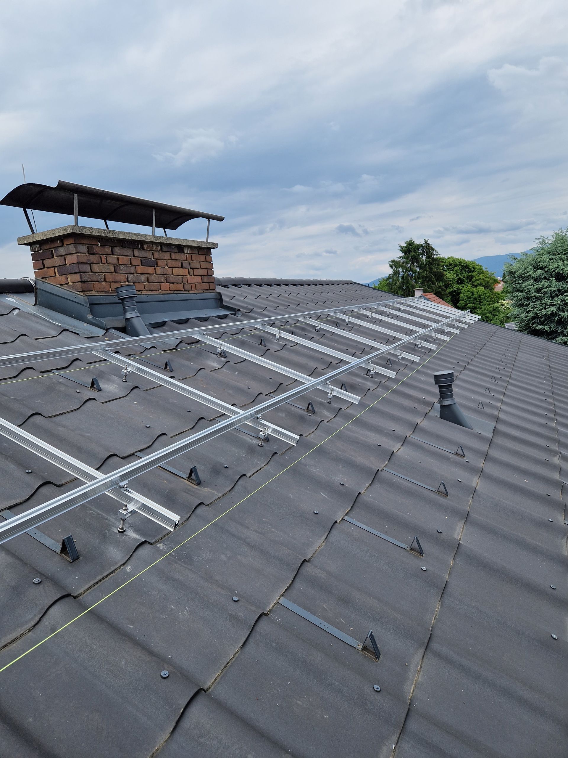 ein Dach mit einer Reihe von Solarpanels und einem Schornstein