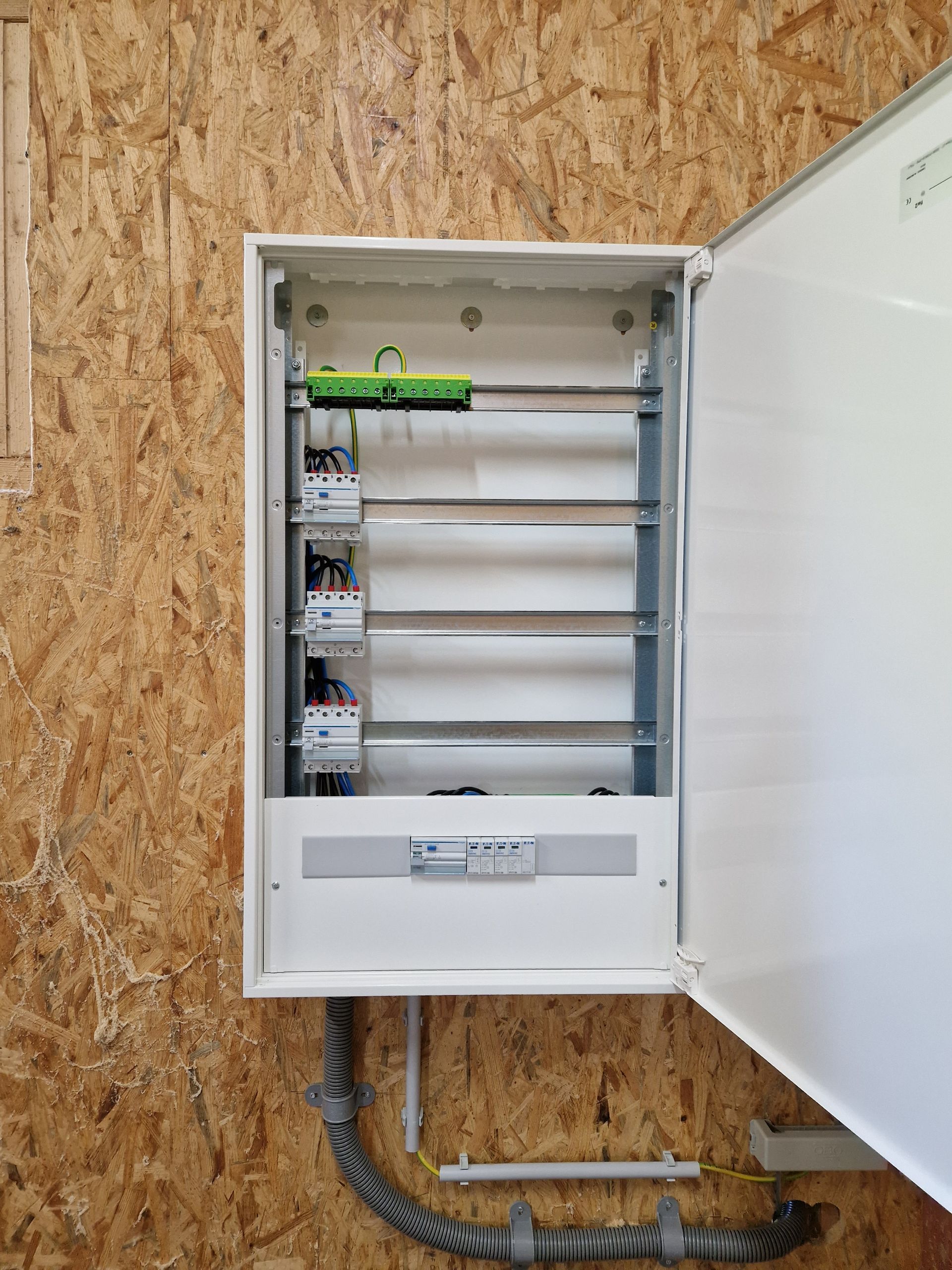 eine weiße elektrische Schaltschrankwand mit einem grünen Stecker darauf