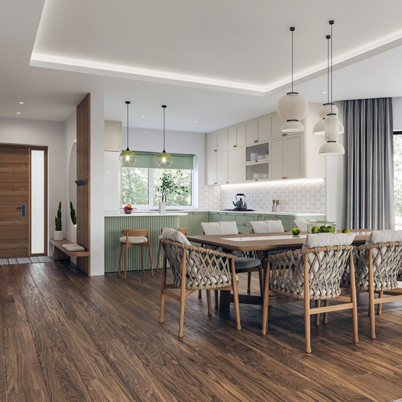 Modern open-plan kitchen and dining area with wood floors, green cabinets, pendant lights, and wicker chairs