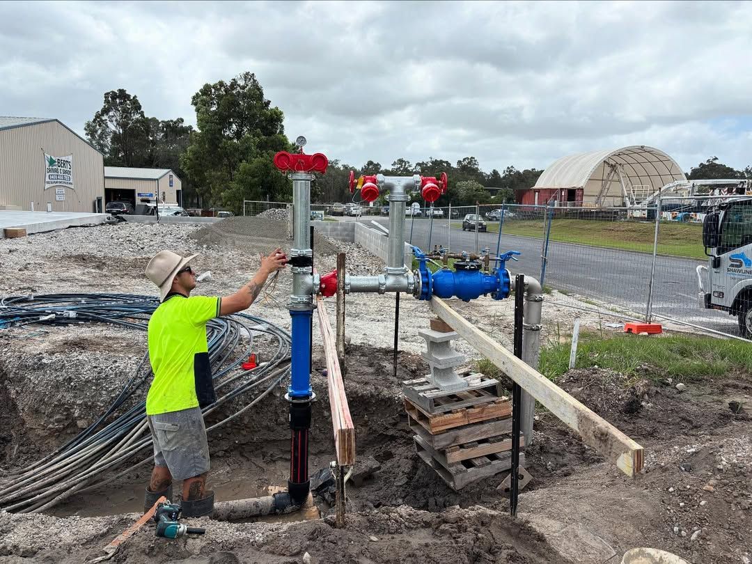 A Man is Working on a Tall Pipe — Shawline Plumbing and Drainage In Iluka, NSW