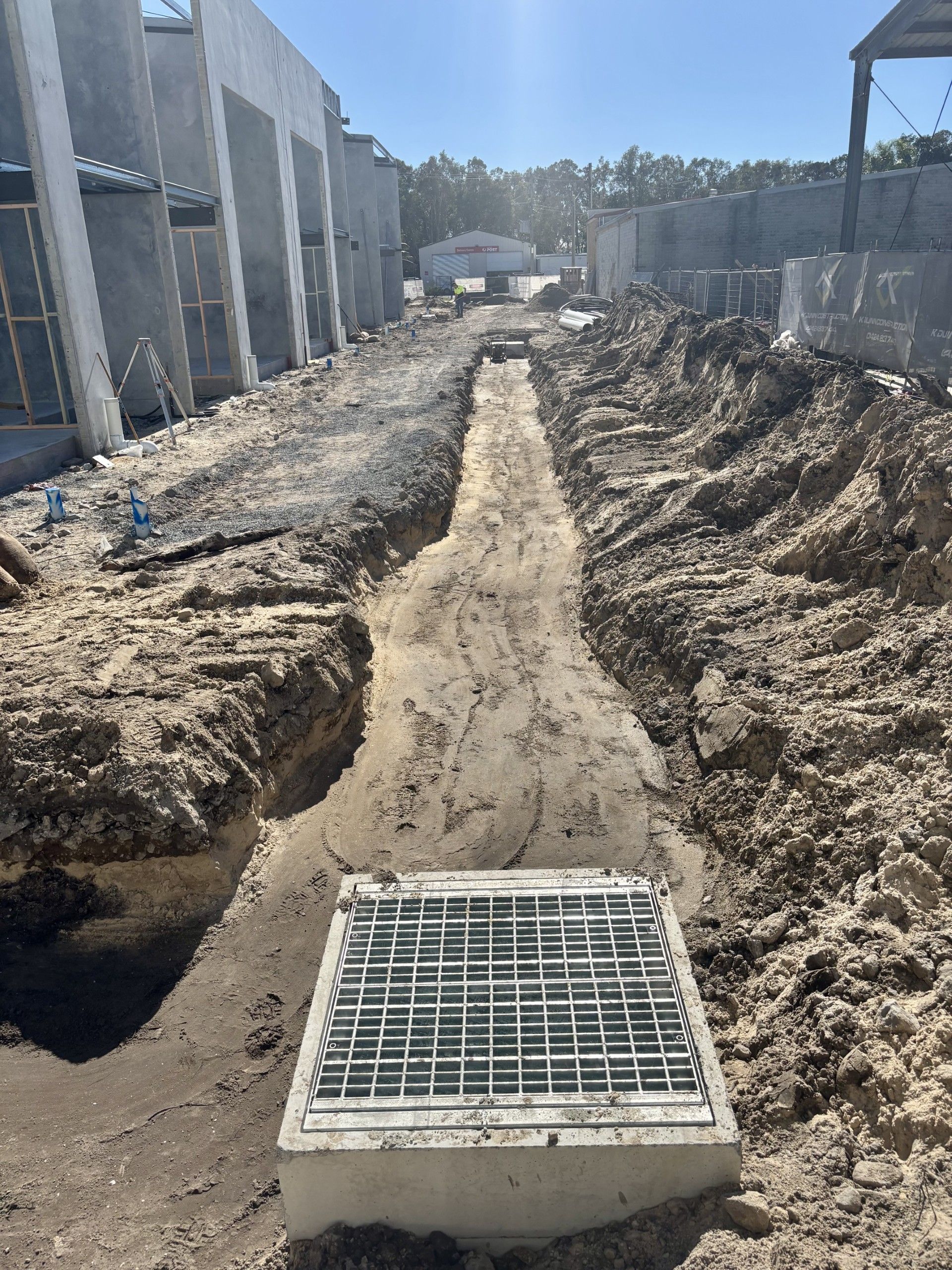 A Man in a Yellow Vest is Working in the Dirt — Shawline Plumbing and Drainage In Iluka, NSW